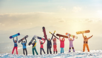 Schneelandschaft mit Sonnenuntergang mit Jugendlichen Schneesportlerinnen und -sportlern